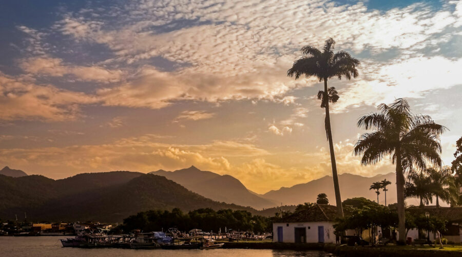 Coucher de soleil sur la baie de Paraty au Brésil, avec reflets dorés sur la mer.